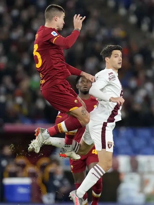Gelandang AS Roma, Gianluca Mancini berebut bola udara dengan pemain Torino, Josip Brekalo pada pertandingan lanjutan Liga Serie A Italia di stadion Olimpiade Roma, Senin (29/11/2021). Sementara itu, Torino tertahan di peringkat ke-13 dengan torehan 17 poin. (AP Photo/Gregorio Borgia)