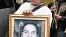 Seorang kerabat menunjukkan foto Faldy Albar saat akan disalatkan di Cinere, Depok, Jawa Barat, Kamis (30/8). Belum diketahui penyebab meninggalnya Faldy Albar. (Liputan6.com/Faizal Fanani)