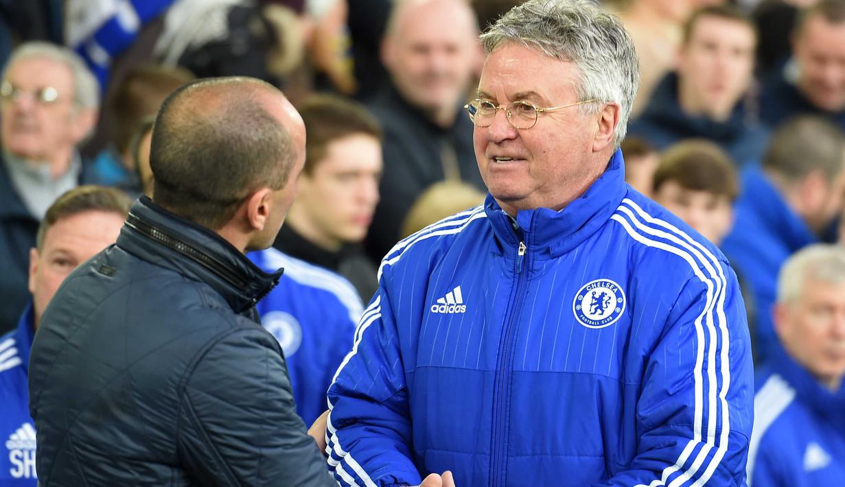 Pelatih Chelsea, Guus Hiddink  memberi salam kepada pelatih Everton, Roberto Martinez usai laga perempat final Piala FA di Goodison Park, Liverpool, Minggu (13/3/2016) dini hari WIB. (AFP/Paul Ellis)