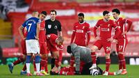 Kapten Liverpool, Jordan Henderson, harus mendapatkan perawatan hingga akhirnya harus meninggalkan lapangan lebih cepat saat memperkuat The Reds menghadapi Everton pada pekan ke-25 Premier League, Minggu (21/2/2021) dini hari WIB. Liverpool kalah 0-2 dalam laga ini. (LAURENCE GRIFFITHS / POOL / AFP)