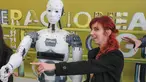 Seorang wanita berpose disamping robot InMoov rancangan Gael Langevin dalam pameran teknologi Bucharest, Romania (26/5). Robot ini dirancang berdasarkan gagasan tangan palsu buatan Langevin yang dikembangkan pada tahun 2011. (AP Photo / Vadim Ghirda)