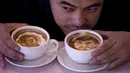 Zach Yonzon memperlihatkan hasil kopi susu latte yang dihiasi wajah Floyd dan Manny Pacquiao di sebuah kafe di Manila, Filipina, Kamis (23/4/2015). (AFP PHOTO/Noel Celis)