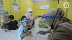 Murid menggunakan face shield belajar iqro di Taman Pendidikan Al-Qur'an (TPA) Al-Muthmainnah Cinere, Depok, Rabu (1/7/2020). Proses belajar mengajar dilakukan dengan protokol kesehatan dimana murid diwajibkan menggunakan masker atau face shield. (merdeka.com/Arie Basuki)