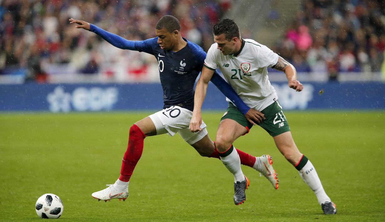 Striker Prancis, Kylian Mbappe, berebut bola dengan bek Irlandia, Derrick Williams, pada laga persahabatan di Stadion Stade de France, Senin (28/5/2018). Prancis menang 2-1 atas Irlandia. (AP/Thibault Camus)