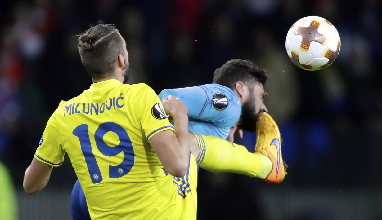 Bek BATE Borisov, Nemanja Milunovic, menendang striker Arsenal, Olivier Giroud, pada laga Liga Europa di Stadion Borisov, Kamis (28/9/2017). Arsenal menang 4-2 atas BATE Borisov. (AP/Sergei Grits)
