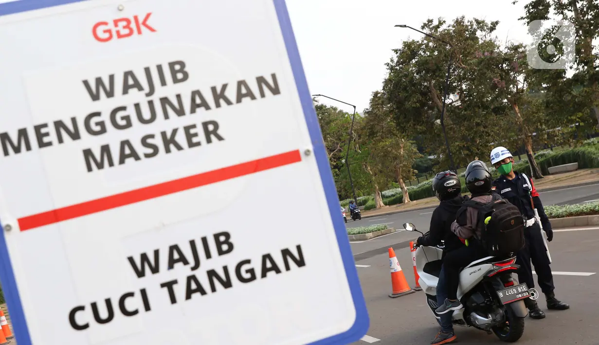 Petugas keamanan memeriksa suhu tubuh pengunjung Stadion Utama Gelora Bung Karno, Jakarta, Sabtu (6/6/2020). SUGBK dibuka kembali untuk kegiatan olahraga masyarakat dengan menerapkan protokol kesehatan pasca keputusan Pemprov DKI Jakarta menerapkan PSBB transisi. (Liputan6.com/Helmi Fithriansyah)