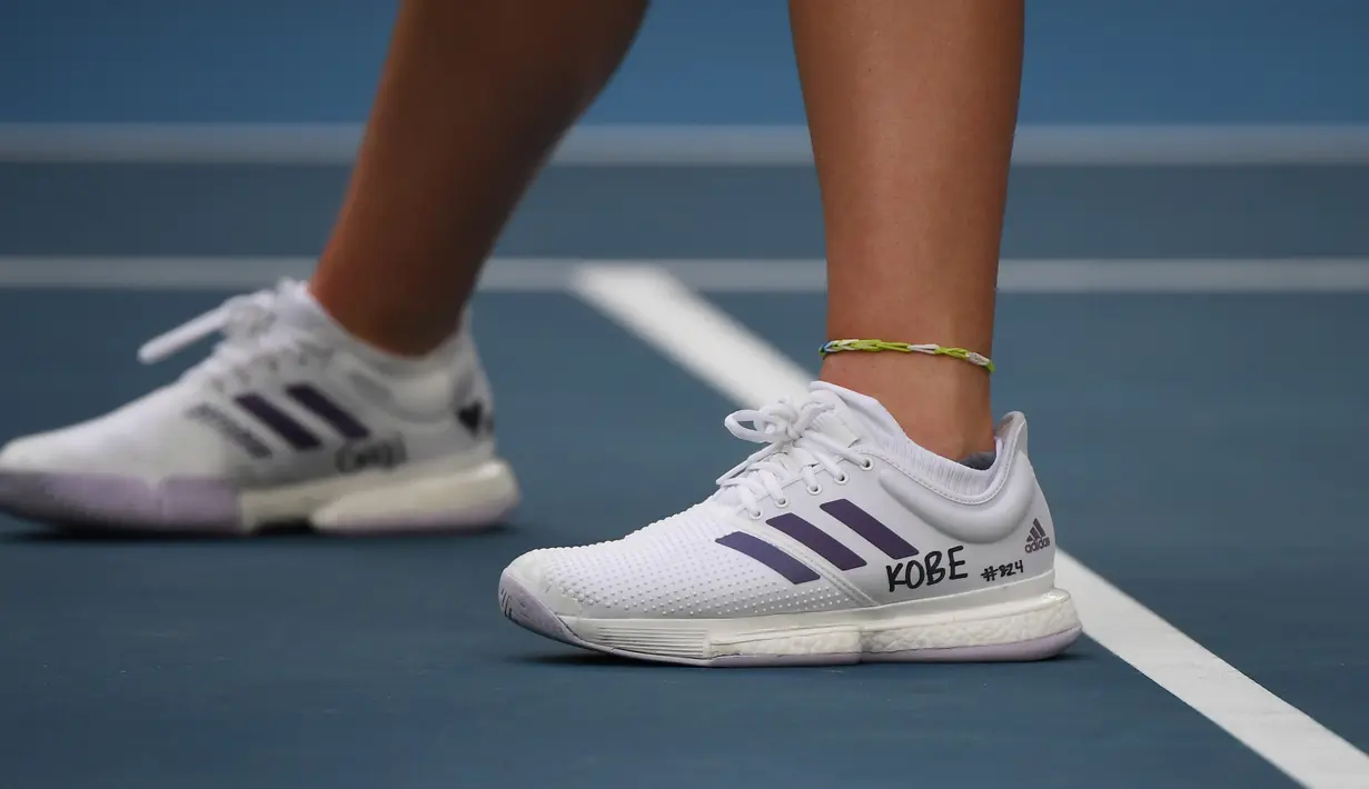 Petenis AS, Catherine McNally memakai sepatu dengan tulisan tangan nama Kobe Bryant pada pertandingan Australia Terbuka 2020 di Melbourne, Senin (27/1/2020).  Para petenis yang meramaikan Australia Terbuka turut berbelasungkawa atas kepergian legenda basket NBA Kobe Bryant. (Manan VATSYAYANA/AFP)