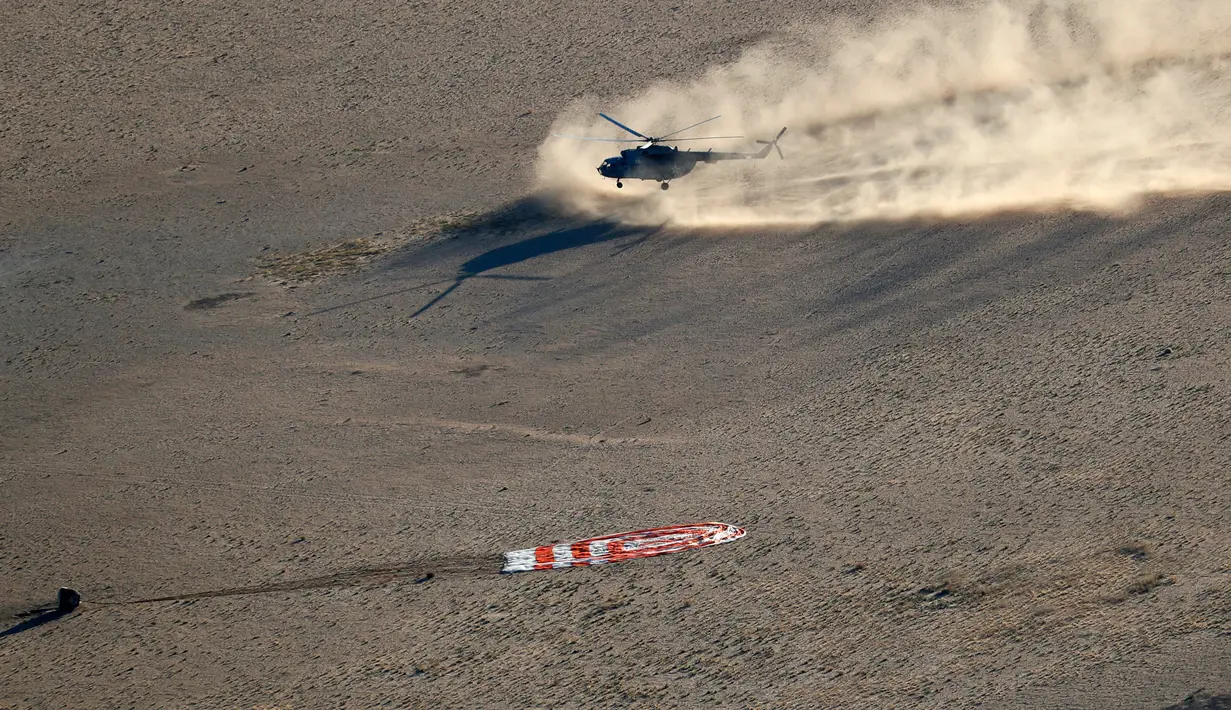 Helikopter penyelamat mendekati kapsul ruang angkasa Soyuz MS-08 yang mendarat di luar Kota Dzhezkazgan, Kazakhstan, Kamis (4/10). Dua astronot AS dan satu kosmonot Rusia balik ke bumi setelah 197 hari di luar angkasa. (Maxim Shipenkov/Pool Photo via AP)