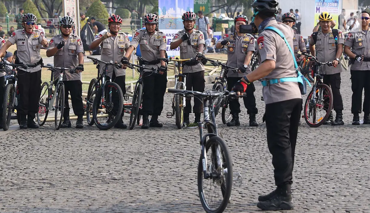 Personel kepolisian berfoto bersama saat mengikuti kegiatan Sepeda Nusantara 2018 di kawasan Monas, Jakarta, Kamis (9/8). Sejumlah pejabat hadir memeriahkan gowes bareng dalam rangka menyambut Asian Games 2018. (Liputan6.com/Immanuel Antonius)