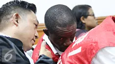 Terdakwa kasus narkotika sabu 6,3 kg Arinze Petrus Eneh berbincang dengan kuasa hukumnya saat mengikuti sidang vonis di PN Jakarta Barat, Rabu (11/5). Sidang dengan tuntutan hukuman mati ditunda hingga minggu depan. (Liputan6.com/Immanuel Antonius)