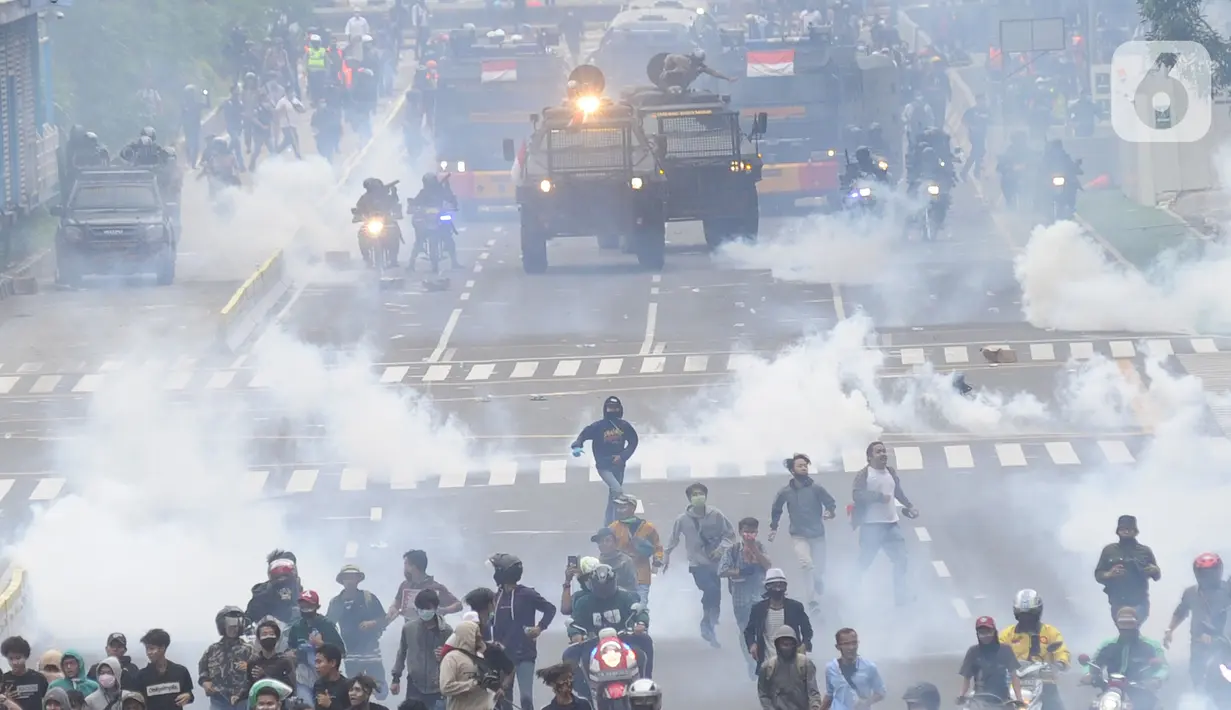 Petugas Brimob Polri menembakkan gas air mata untuk membubarkan massa usai terjadi lemparan batu di Jalan MH Thamrin, Jakarta, Selas (13/10/2020). Massa pengunjuk rasa yang menolak Omnibus Law akhirnya dibubarkan aparat. (merdeka.com/Arie Basuki)