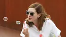 Sama-sama di Venice, Anne Hathaway santai banget nih meniup balon sabun. (AMA/MEGA/USWeekly)