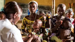 Seorang wanita memegang anaknya saat di ukur untuk pemeriksaan gizi buruk di Pusat kesehatan di Mbau, Republik Demokratik Kongo (15/11). Akibat krisis dan kemiskinan membuat rakyat, terutama anak-anak Kongo menderita gizi buruk. (AFP/ Eduardo Soteras)