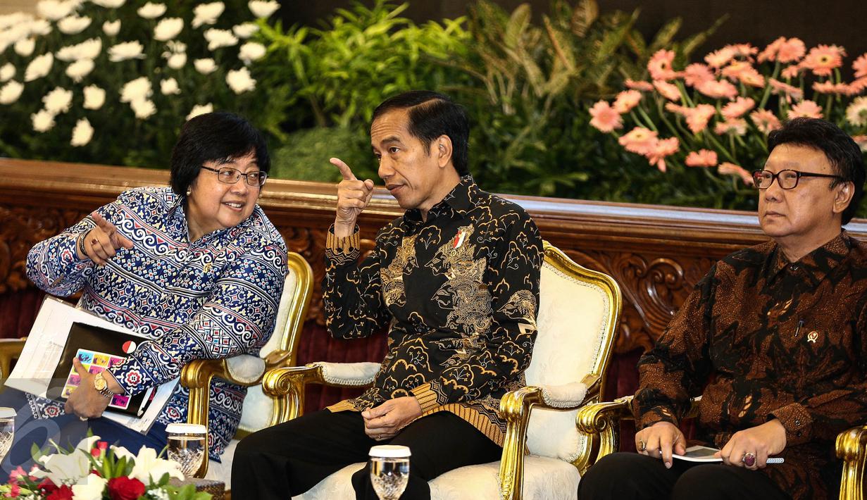 Presiden Joko Widodo berbincang dengan Menteri Lingkungan Hidup dan Kehutanan Siti Nurbaya saat menghadiri pencanangan pengakuan hutan adat di Istana Negara, Jakarta, Jumat (30/12). (Liputan6.com/Faizal Fanani)