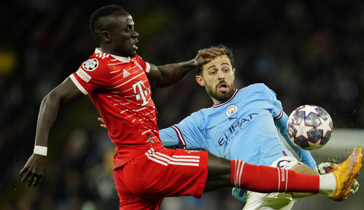 Striker Bayern Munchen, Sadio Mane (kiri) berebut bola dengan gelandang Manchester City, Bernardo Silva pada laga leg pertama babak perempatfinal Liga Champions 2022/2023 di Etihad Stadium, Manchester, Rabu (12/4/2023) dini hari WIB. (AP Photo/Jon Super)