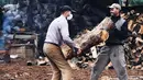 Para pekerja menggotong kayu bakar di sebuah bengkel kerja di Damaskus, ibu kota Suriah, pada 23 November 2020. Warga Suriah mengumpulkan kayu bakar untuk menghadapi cuaca dingin. (Xinhua/Ammar Safarjalani)
