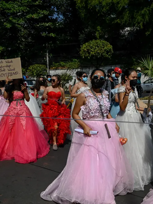 Sejumlah wanita Myanmar memakai gaun pengantin memegang plakat selama demonstrasi menentang kudeta militer 1 Februari di Yangon (10/2/2021).  Militer Myanmar melakukan kudeta pada 1 Februari dan menahan sejumlah tokoh termasuk Aung San Suu Kyi. (AFP/ Ye Aung Thu)