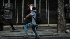 Pengunjuk rasa melemparkan petasan ke arah polisi saat bentrokan memprotes rencana pembatasan belanja publik di Rio de Janeiro, Brasil, (9/2). (AFP Photo / Yasuyoshi Chiba)