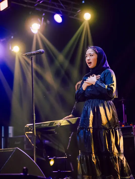Tampil serba hitam, Bernadya memilih busana yang anggun dan minimalis, menunjukkan gaya khasnya yang tetap elegan namun tetap sesuai dengan norma budaya setempat. Stylist andal @muhafiattt berhasil memadukan busana serba hitam dengan kerudung yang sempurna, menciptakan harmoni visual yang memikat.