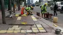 Pekerja memasang jalur khusus tunanetra dalam penataan jalur pedestrian di Jalan Gatot Subroto, Jakarta, Selasa (13/3). Pemprov DKI menata pedestrian untuk memberi kenyamanan dan keamanan bagi pejalan kaki. (Liputan6.com/Arya Manggala)