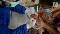 Perawat dibantu kader Posyandu memberikan vaksin campak, vaksin pentabio berisi vaksin DPT, Hepatitis B dan Haemophilus Influenzae dan Imunisasi Polio terhadap anak di RW 09, Kelurahan Pondok Benda, Tangerang Selatan, Senin (14/12/2020). (merdeka.com/Dwi Narwoko)