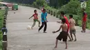 Anak-anak bermain sepak bola di jalur inspeksi Sungai Ciliwung di kawasan Rawajati, Jakarta, Rabu (23/1). Keterbatasan lahan tidak menyurutkan semangat mereka untuk bermain sepak bola meski di tempat seadanya. (Liputan6.com/Immanuel Antonius)