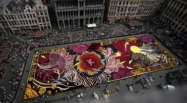 Para sukarelawan bekerja menempatkan bunga begonia ke dalam karpet bunga raksasa bertema Art Nouveau di Grand Place yang bersejarah di Brussels, Belgia, Kamis, 15 Agustus 2024. (AP Photo/Virginia Mayo)