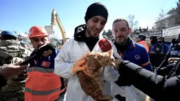 Seorang petugas penyelamat menunjukkan seekor kucing kepada media setelah diselamatkan dari sebuah bangunan yang runtuh, 248 jam setelah gempa berkekuatan 7,8 magnitudo yang melanda sebagian wilayah Turki dan Suriah, di Kahramanmaras, Turki, Kamis (16/2/2023). Korban tewas akibat gempa Turki-Suriah per Rabu (15/2) bertambah menjadi 41.132 orang, hingga kini, tim penyelamat baik dari dalam negeri maupun komunitas internasional masih terus melakukan pencarian dan penyelamatan. (OZAN KOSE/AFP)