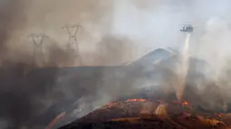 Helikopter pemadam kebakaran melakukan tetesan air saat Route Fire terbakar di dekat Castaic, California (31/8/2022). Evakuasi telah diperintahkan karena kebakaran hutan telah menghanguskan lebih dari 600 hektar dan menutup jalan bebas hambatan 5 di tengah gelombang panas di California Selatan. (Mario Tama/Getty Images/AFP)