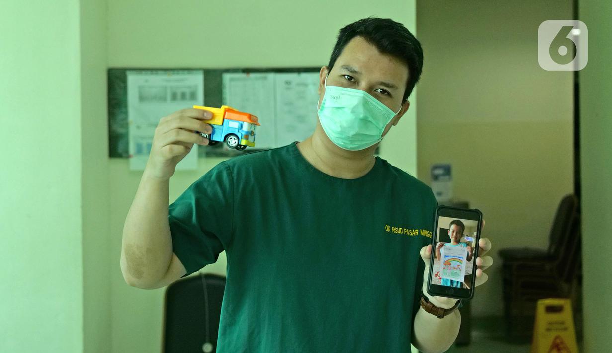 dr. Juan Cipta (30) menunjukkan foto anaknya saat di RSUD Pasar Minggu, Jakarta, Jumat (22/5/2020). Juan Cipta sudah 2 bulan tidak bertemu keluarga selama bertugas menjaga COVID -19 di RSUD Pasar Minggu. (Liputan6.com/Herman Zakharia)