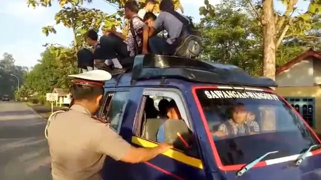 Polisi menghentikan angkutan yang memuat penumpang di atap kendaraan. (Liputan6.com/Polres Cilacap/Muhamad Ridlo)