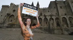 Model asal Brasil, Juliana Marques menunjukkan plakat dengan tulisan "Sirkus, penjara untuk binatang" saat melakukan aksi di Avignon, Prancis (11/2). Aksi model ini menjadi pusat perhatian warga setempat. (AFP Photo / Boris Horvat)