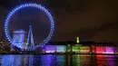 Cahaya biru menerangi London Eye di tepi Sungai Thames untuk berterima kasih kepada National Health Service (NHS) di London, Kamis (7/1/2021). NHS merupakan sistem layanan kesehatan nasional yang menjadi ujung tombak Inggris dalam memerangi pandemi Covid-19. (AP Photo/Kirsty Wigglesworth)