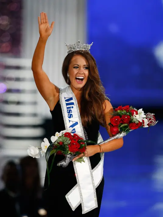 Miss North Dakota 2017, Cara Mund melambaikan tangan ke penonton seusai dinobatkan sebagai Miss America 2018 dalam ajang kecantikan yang digelar di Boardwalk Hall Arena di Atlantic City, New Jersey (10/9). (AP Photo/ Noah K. Murray)