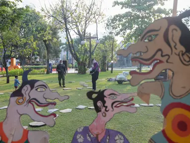 Pengunjung mengamati karya dalam pameran seni rupa kontemporer luar ruang Jakarta Provoke! di Taman Menteng, Jakarta Pusat, Jumat (17/7/2026). Pameran gratis yang berlangsung hingga 26 Juli 2026 ini menghadirkan 25 karya dari 25 seniman dan kolektif tentang dinamika kehidupan Jakarta. (KLY/Budy Santoso)