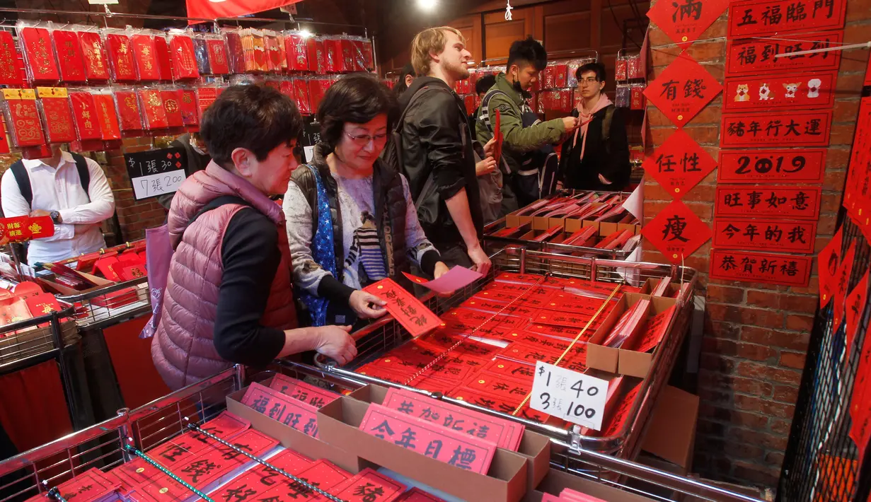 Orang-orang berbelanja untuk persiapan Tahun Baru Imlek di pasar Dihua Street di Taipei, Selasa (29/1). Warga Taiwan mulai berburu makanan lezat, kue kering dan barang-barang diskon di pasar menjelang Imlek pada 5 Februari 2019. (AP/Chiang Ying-ying)