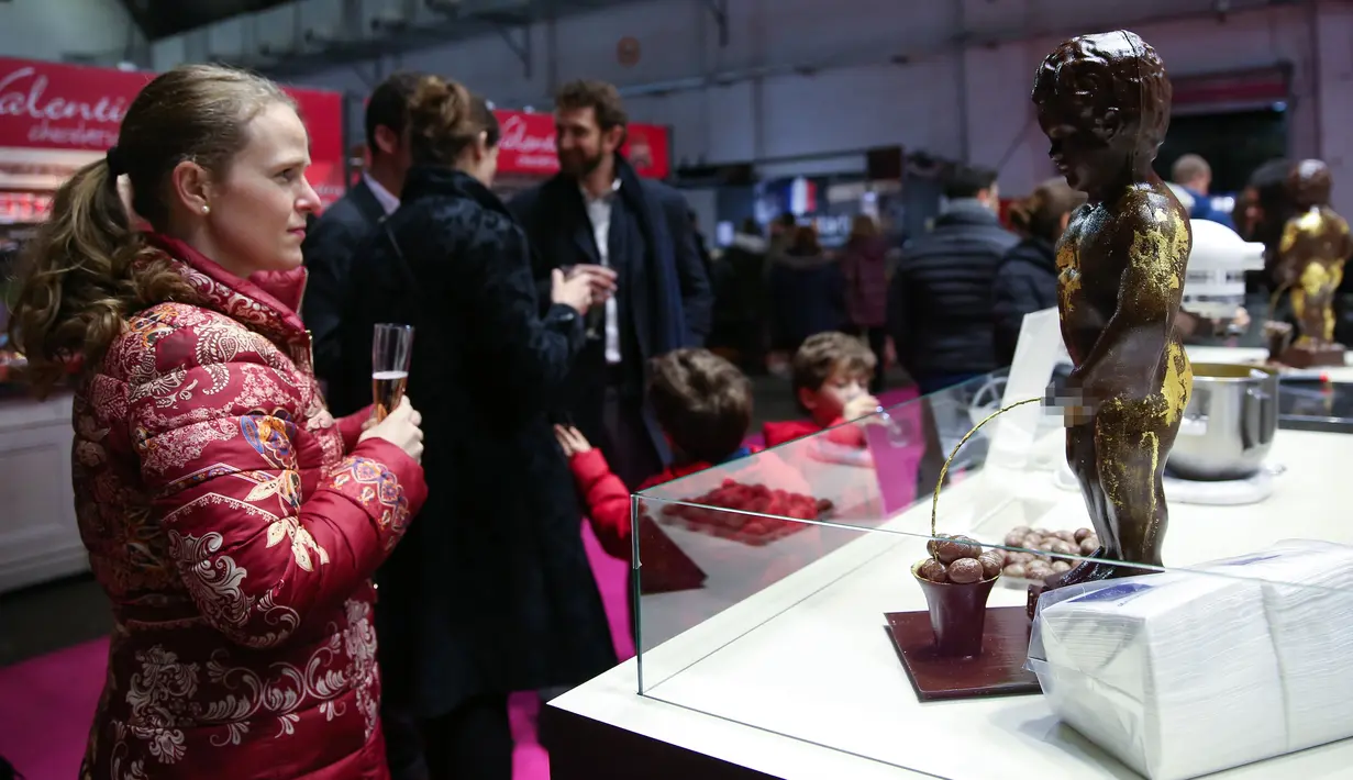 Seorang pengunjung melihat "Manneken Pis" yang terbuat dari cokelat di Pameran Cokelat Brussel ketujuh di Brussel, Belgia (13/2/2020). (Xinhua/Zhang Cheng)