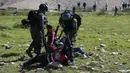 Seorang petugas medis ditodongkan senjata oleh tentara Israel ketika berusaha mengobati demonstran yang terlibat bentrokan di Ramallah, Tepi Barat, Senin (12/3). Aksi protes terkait pengangkapan salah satu mahasiswa oleh pasukan Israel. (ABBAS MOMANI/AFP)