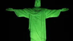 Patung ini memiliki warna pencahayaan yang berubah menjadi hijau untuk menarik perhatian tentang pentingnya menjaga kelestarian lingkungan. (CARL DE SOUZA / AFP)