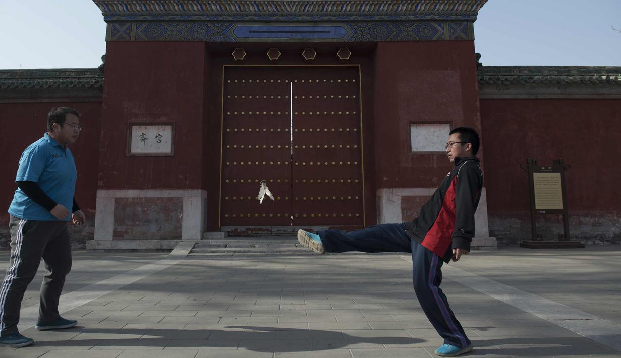 Seorang pria menendang sebuah shuttlecock dalam sebuah permainan tradisional di Ditan Park di Beijing (1/2). Tahun Baru Imlek jatuh pada 16 Februari tahun ini, dengan perayaan yang berlangsung selama seminggu di China. (AFP Photo/Nicolas Asfouri)