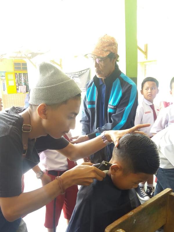 Para siswa SDN 1 Bayongbong, Garut nampak asik saat pelaksanaan cukur rambut gratis saat Hari Anak Sedunia (Liputan6.com/Jayadi Supriadian)