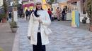Penampilan wanita 49 tahun kali ini pun tampak modis dengan coat putih serta topi senada. (Instagram/iisdahlia).