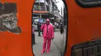 Fashionista Kenya, James Mwangi Maina bermain ponsel sambil memamerkan setelan jasnya yang senada dengan pakaian dan aksesorisnya, termasuk masker di Nairobi, 5 Agustus 2020. Mwangi mengklaim dirinya memiliki penampilan terbaik dan paling stylish di Afrika. (Simon MAINA/AFP)