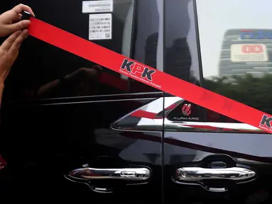 Petugas Komisi Pemberantasan Korupsi (KPK) memasang garis pembatas di samping mobil Alphard hasil sitaan penggeledahan rumah dinas Wakil Menteri Ketenagakerjaan (Wamenaker) Immanuel Ebenezer di kawasan Pancoran, Jakarta Selatan, Selasa (26/8/2025). (Liputan6.com/Helmi Fithriansyah)