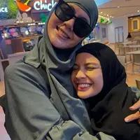 Di depan Ka’bah, Nagita Slavina memancarkan pesona anggun mengenakan khimar dan gamis serba hitam. Penampilannya dilengkapi dengan tas Hermes. [@raffinagita1717]
