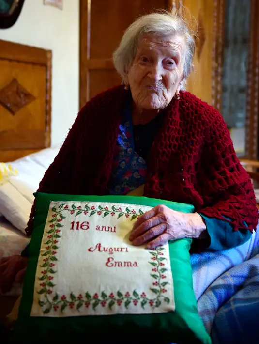 Emma Morano (116) memegang bantal bertuliskan '116 Tahun, Happy Birthday Emma' saat berpose ditemui di Verbania, Italia Utara, 14 Mei 2016. Emma Morano adalah orang tertua di dunia yang lahir di Vercelli dari delapan bersaudara. (Olivier MORIN/AFP)