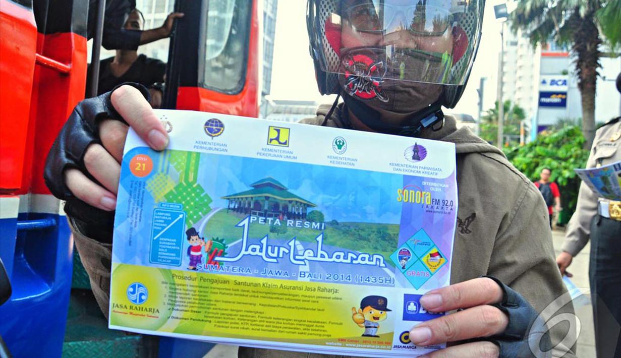 Seorang pengendara roda dua memperlihatkan peta mudik yang didapatnya secara gratis, Jakarta, Jumat (18/07/2014)(Liputan6.com/Faizal Fanani)