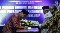 Gubernur Bank Indonesia (BI) Agus Martowardoyo menandatangani nota kesepahaman (Mou) dengan MUI, Baznas, dan BWI di Gedung MUI, Jakarta, Rabu (24/1). (Liputan6.com/Faizal Fanani)