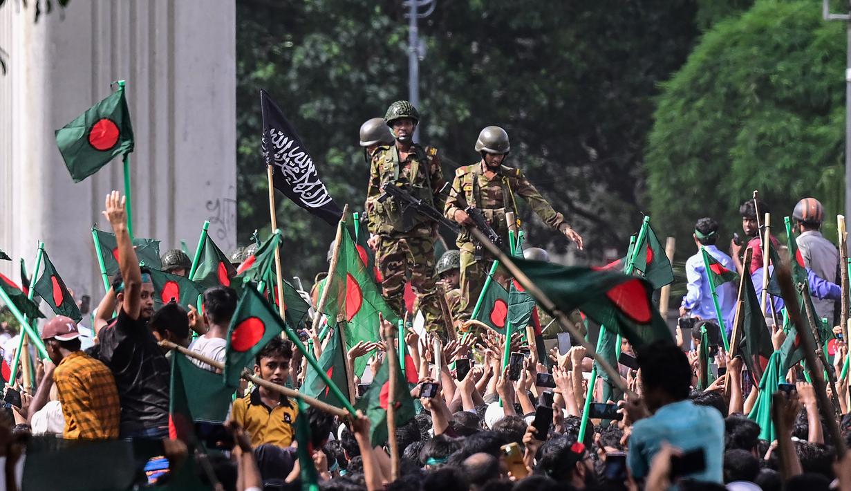 Tentara dan polisi dengan kendaraan lapis baja di Dhaka telah membarikade rute menuju kantor Hasina dengan kawat berduri, namun massa dalam jumlah besar membanjiri jalan-jalan, merobohkan penghalang. (Munir UZ ZAMAN / AFP)