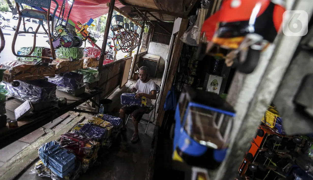 Marsyaad atau biasa dipanggil Pak Umar (79) membuat mobil-mobilan di toko mainan miliknya di Kalibata, Jakarta, Kamis (25/2/2021). Pak Umar yang menjual mainan anak sejak tahun 1974 mengaku tidak terlalu berdampak saat pandemi virus corona COVID-19 berlangsung. (Liputan6.com/Johan Tallo)